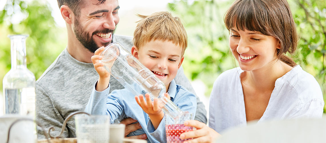 Familie mit reinem Trinkwasser und Wasserfilter Familie mit reinem Trinkwasser und Wasserfilter